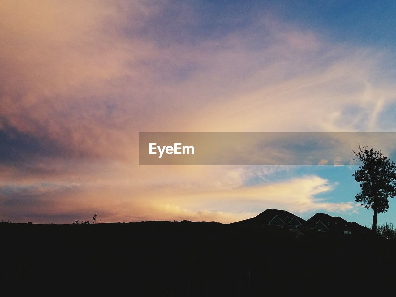 SILHOUETTE OF MOUNTAINS AGAINST DRAMATIC SKY