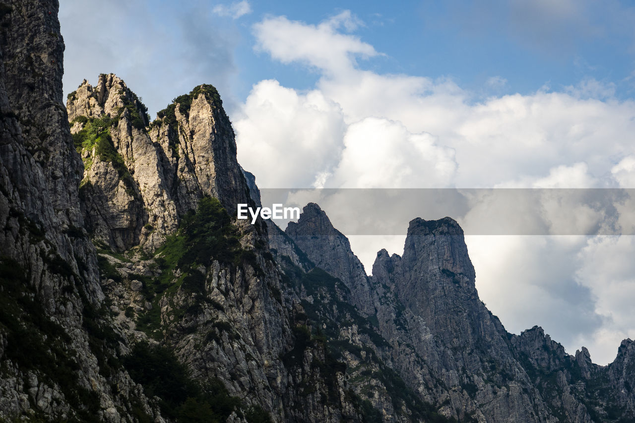 Low angle view of rocky mountains against sky