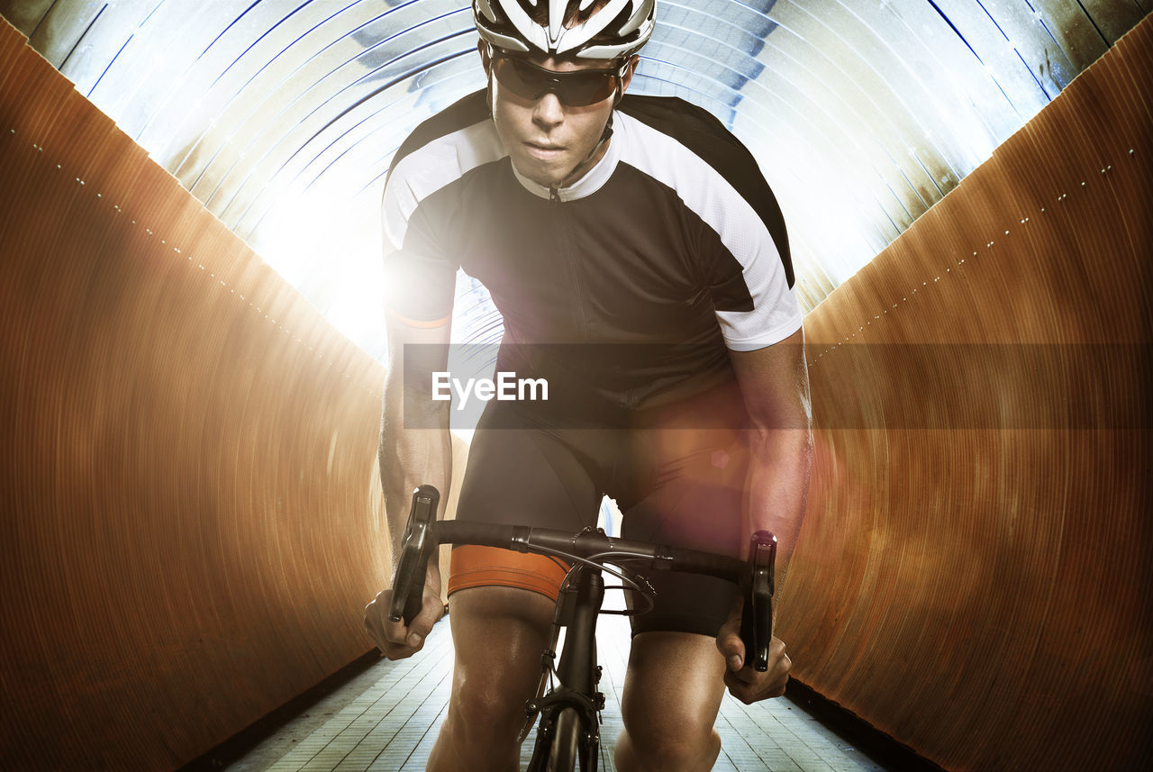 Man cycling through tunnel
