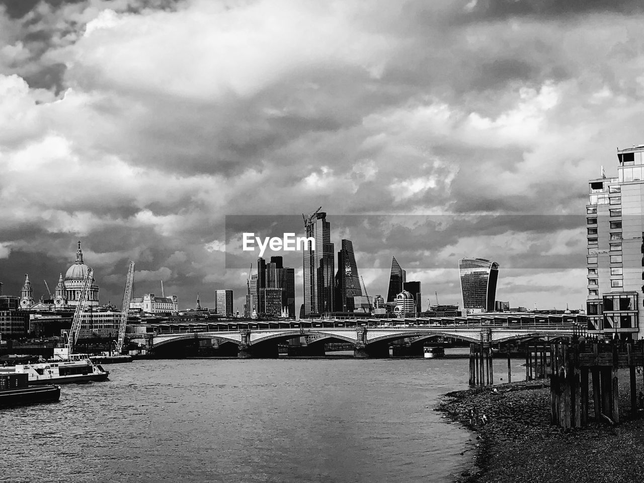 BRIDGE OVER RIVER AND BUILDINGS AGAINST SKY