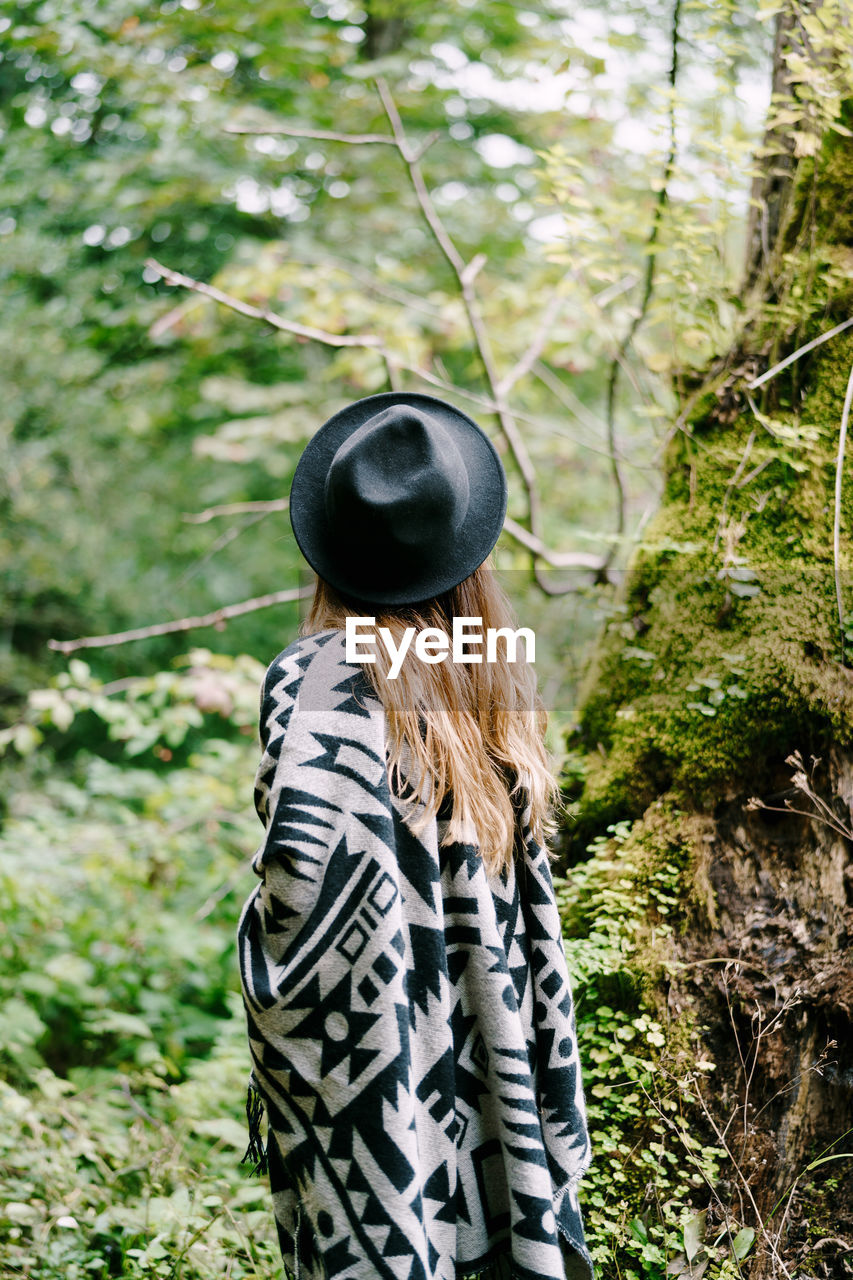 Rear view of woman wearing hat in forest