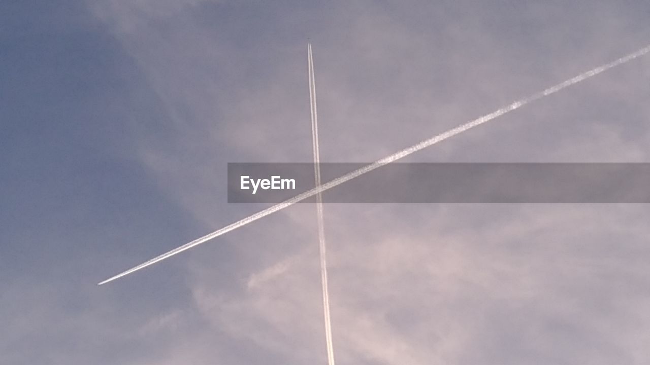 LOW ANGLE VIEW OF VAPOR TRAILS AGAINST SKY