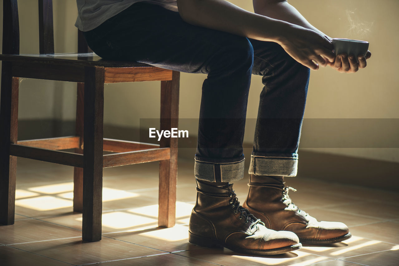 Low section of man sitting on tiled floor