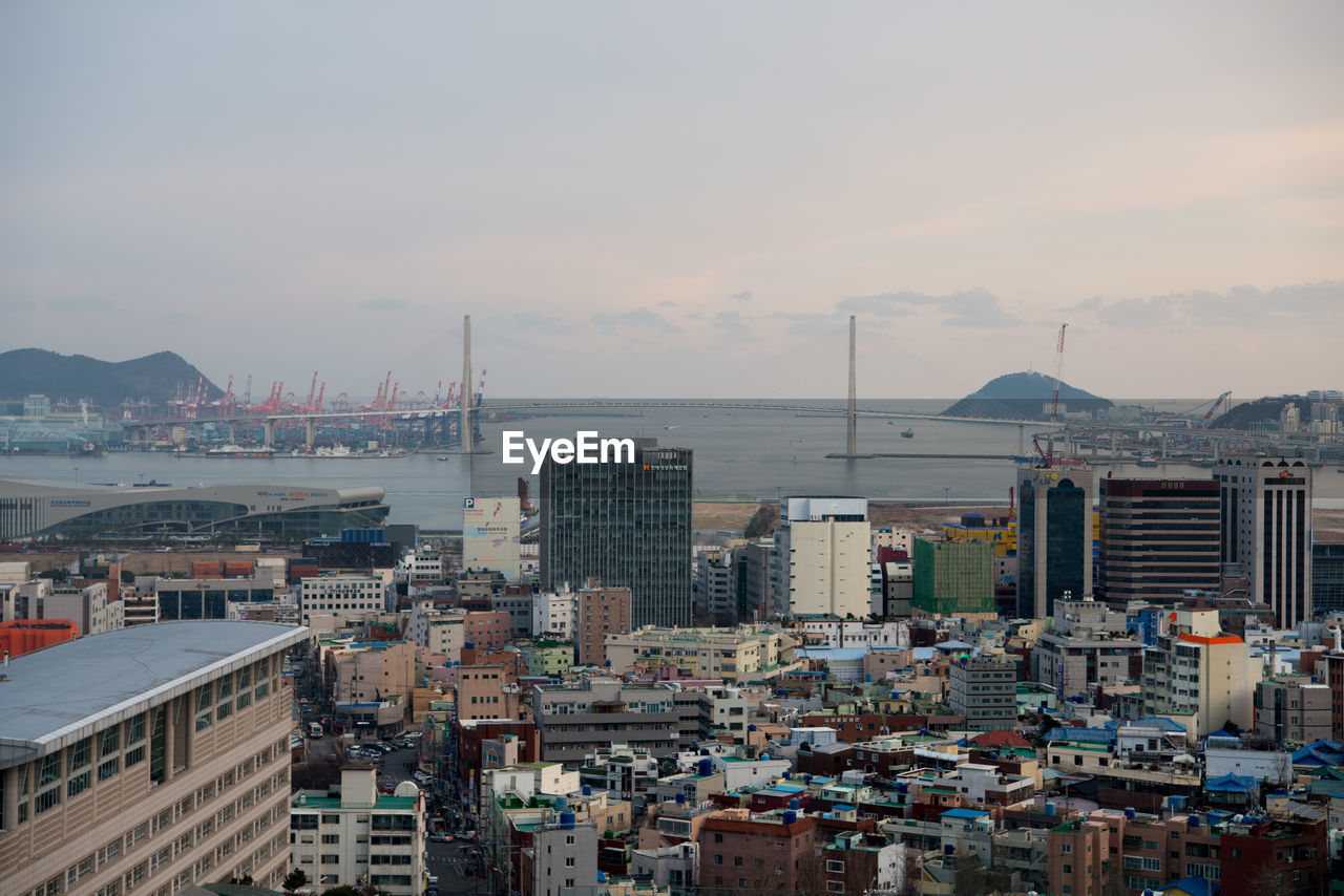 View of cityscape against cloudy sky