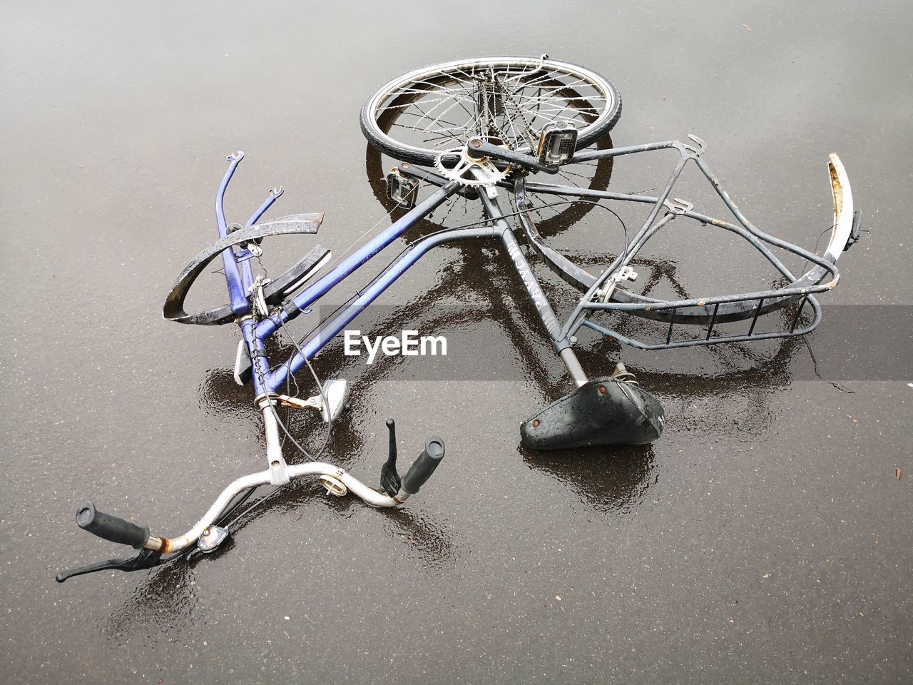 High angle view of broken bicycle on wet road