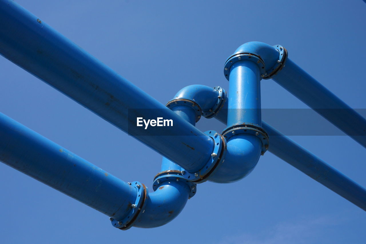Low angle view of blue pipelines against clear blue sky