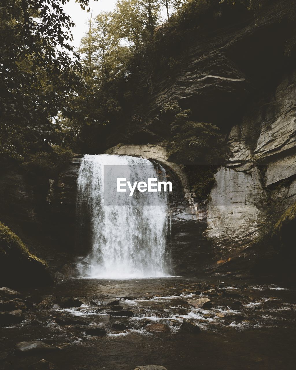 SCENIC VIEW OF WATERFALL AGAINST SKY