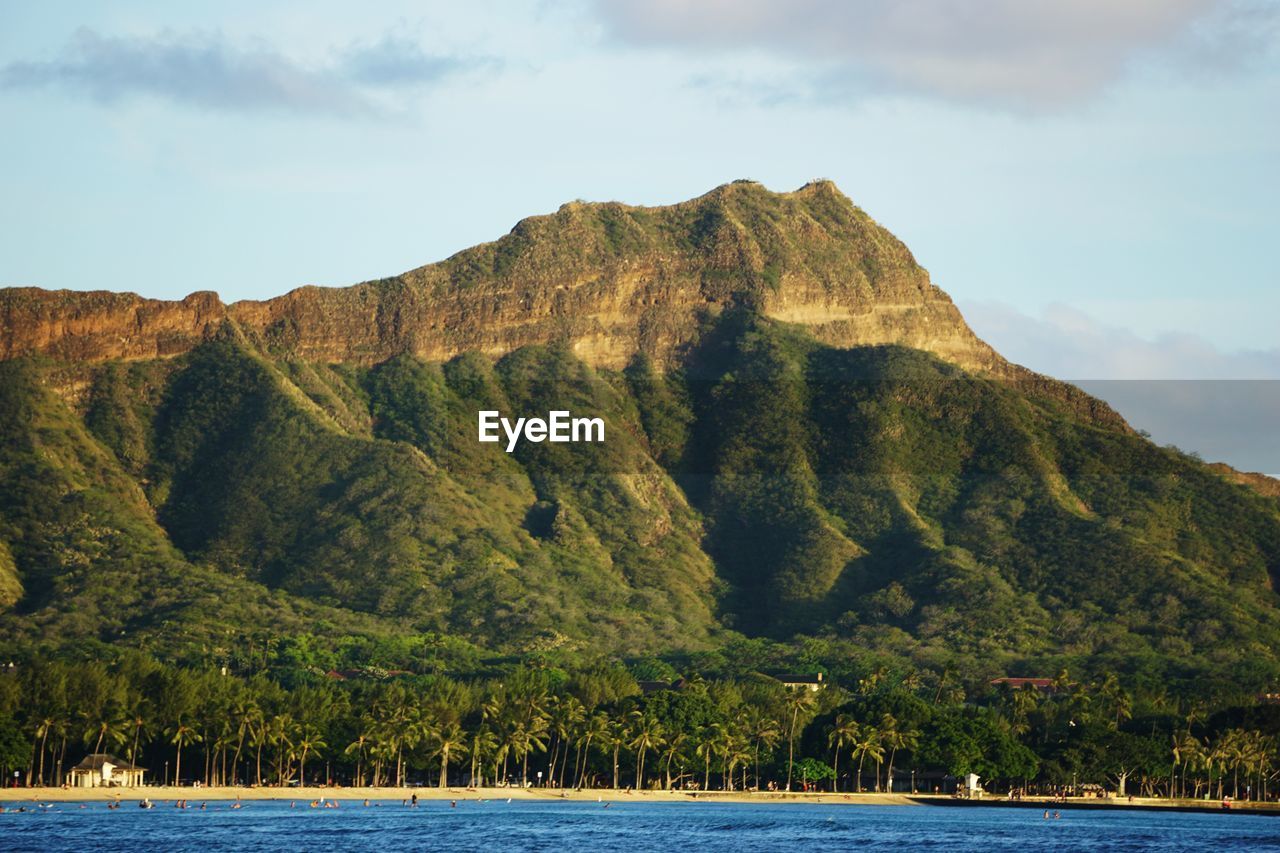 Scenic view of mountain by sea against sky