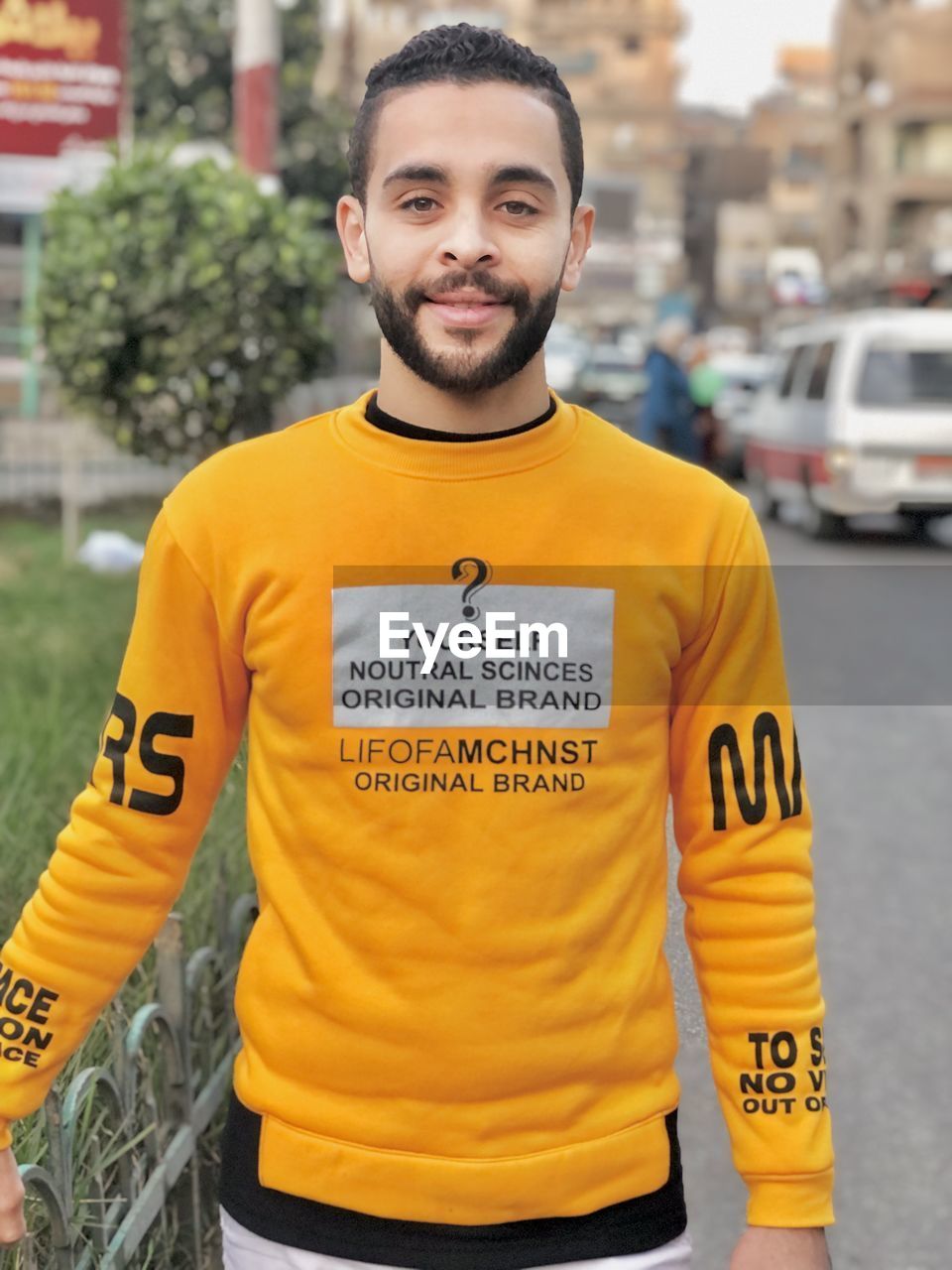 portrait of young man standing against building