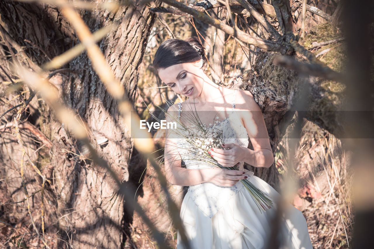 Bride standing by dry plants