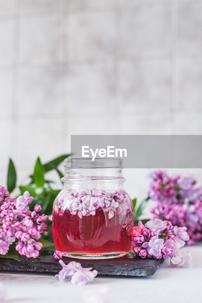 Preparation of syrup from the lilac flowers. glass jar of lilac syrup and branch of lilac flowers 