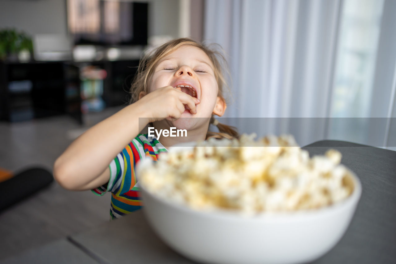 portrait of young woman having food at home