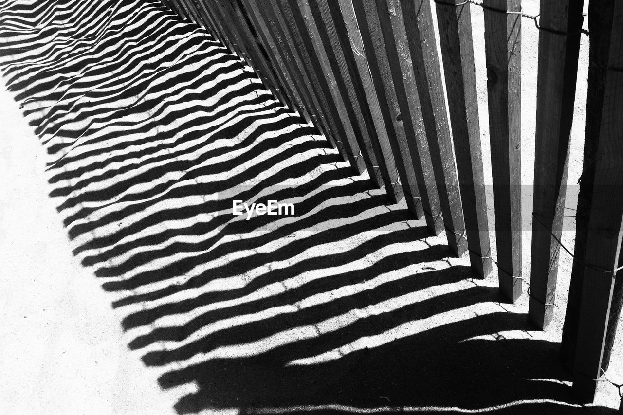 High angle view of wooden fence shadow