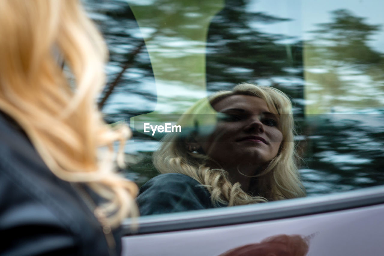 Woman reflecting on car window