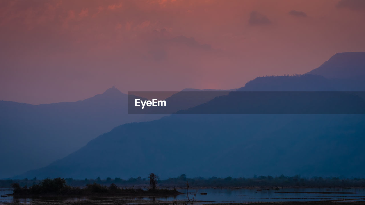 SCENIC VIEW OF SILHOUETTE MOUNTAINS AGAINST SKY DURING SUNSET