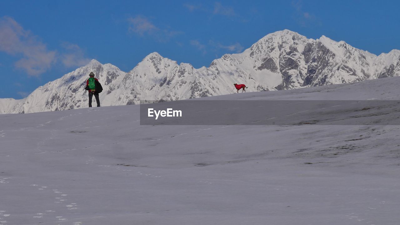 rear view of man walking on snow covered mountain