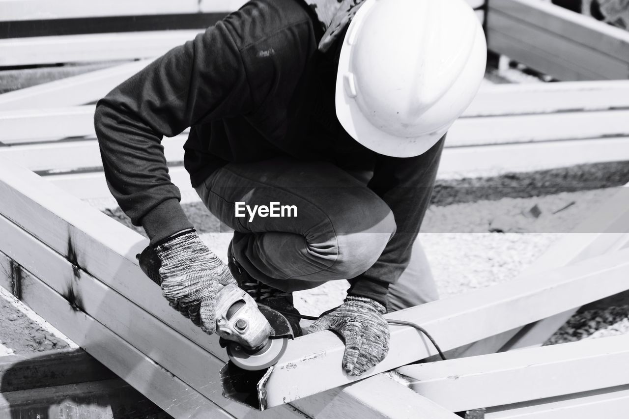 Construction worker cutting metal at site