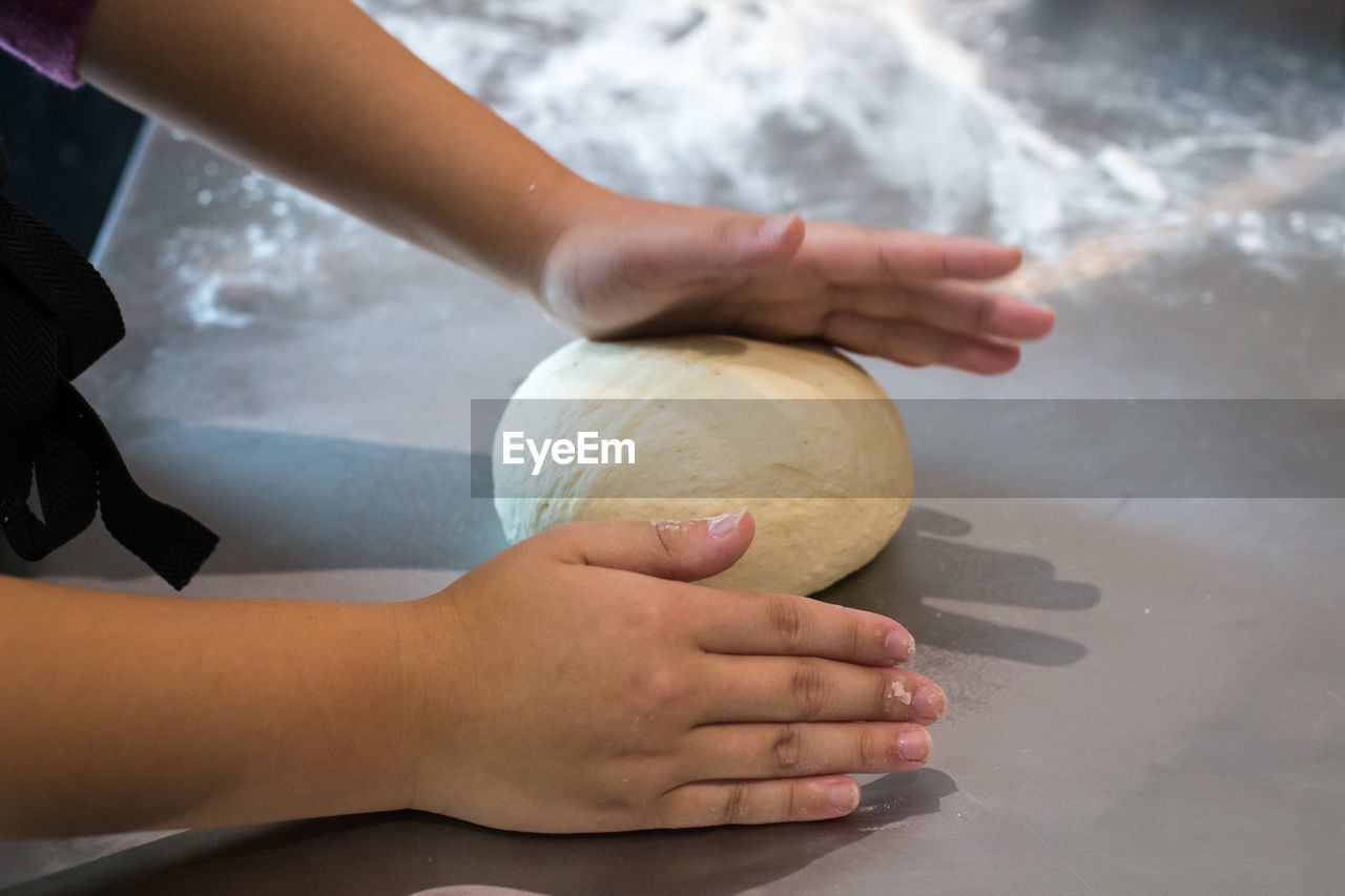 CLOSE-UP OF HAND HOLDING BALL AGAINST THE BACKGROUND