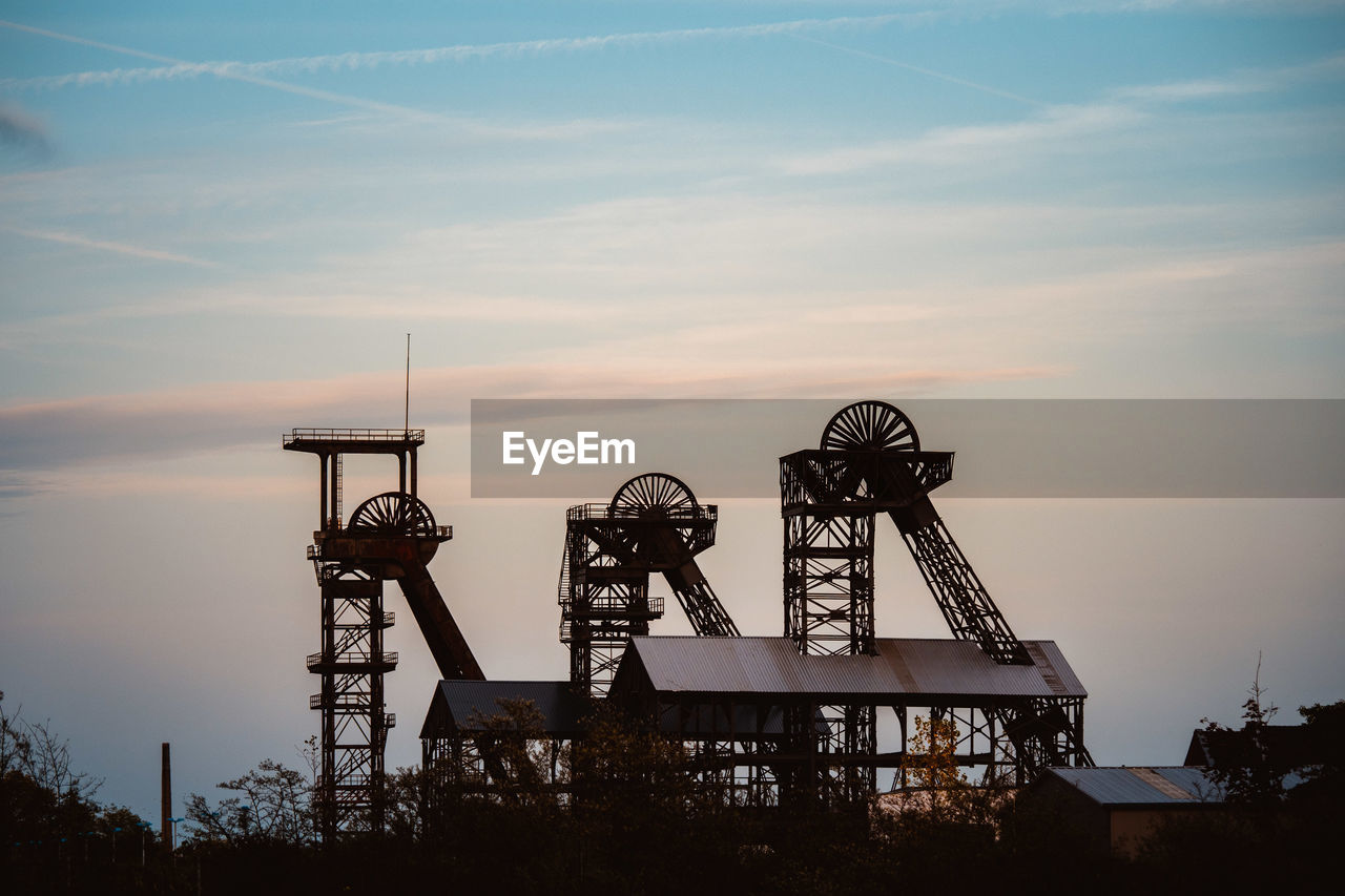 LOW ANGLE VIEW OF SILHOUETTE CRANE AGAINST SKY DURING SUNSET