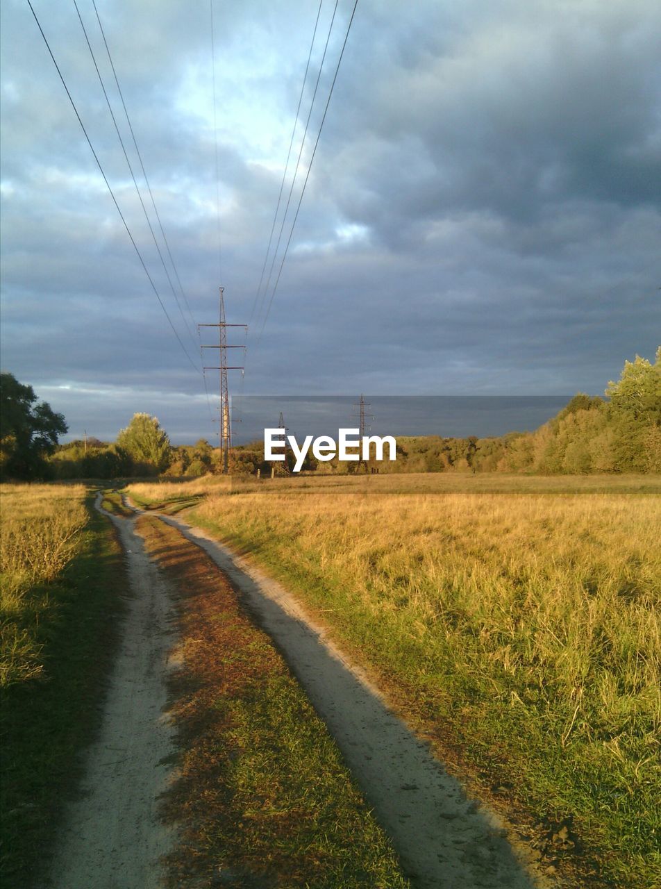 ELECTRICITY PYLON ON ROAD AGAINST SKY