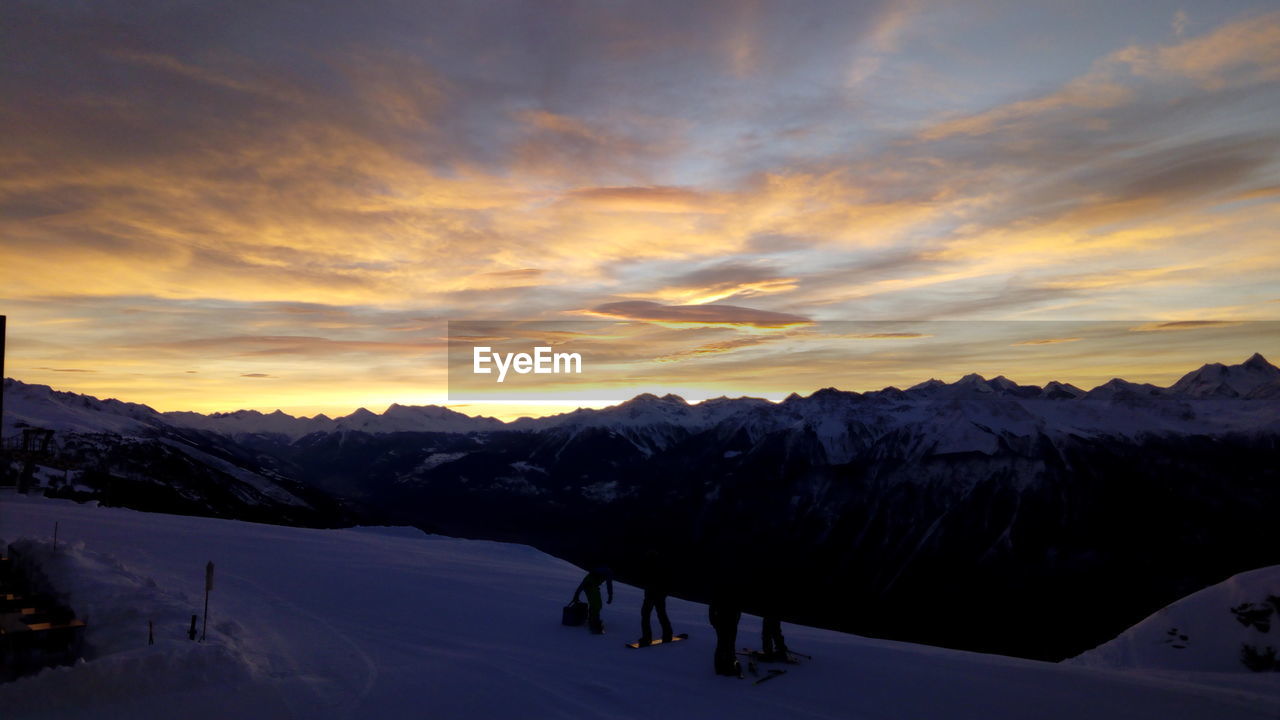 Scenic view of snowcapped mountains against sky during sunset