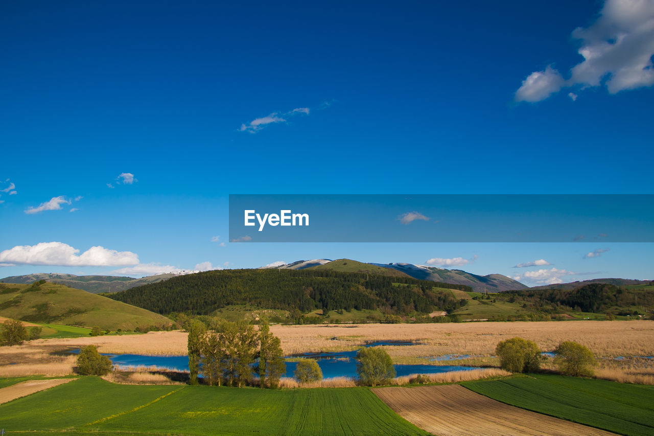 Scenic view of landscape against blue sky