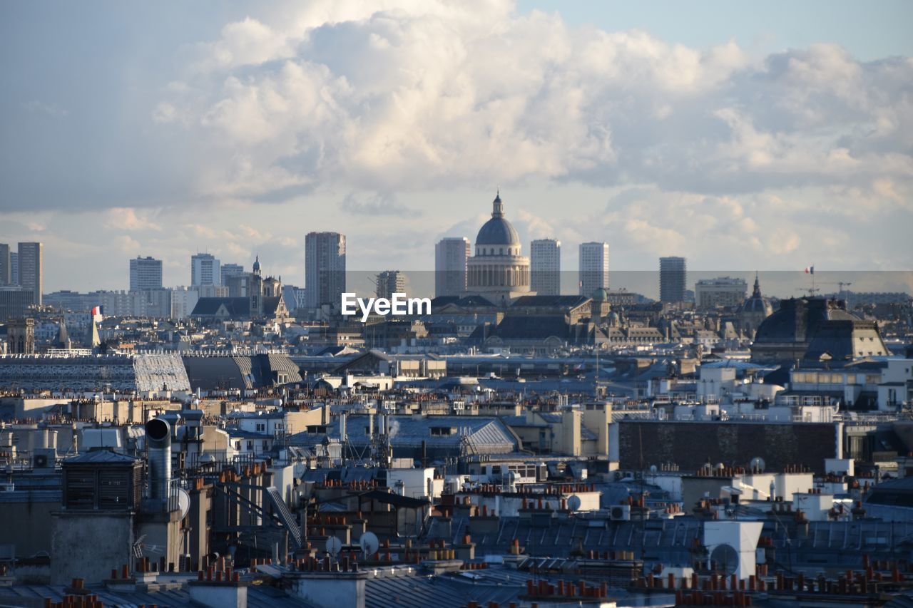 Cityscape against cloudy sky