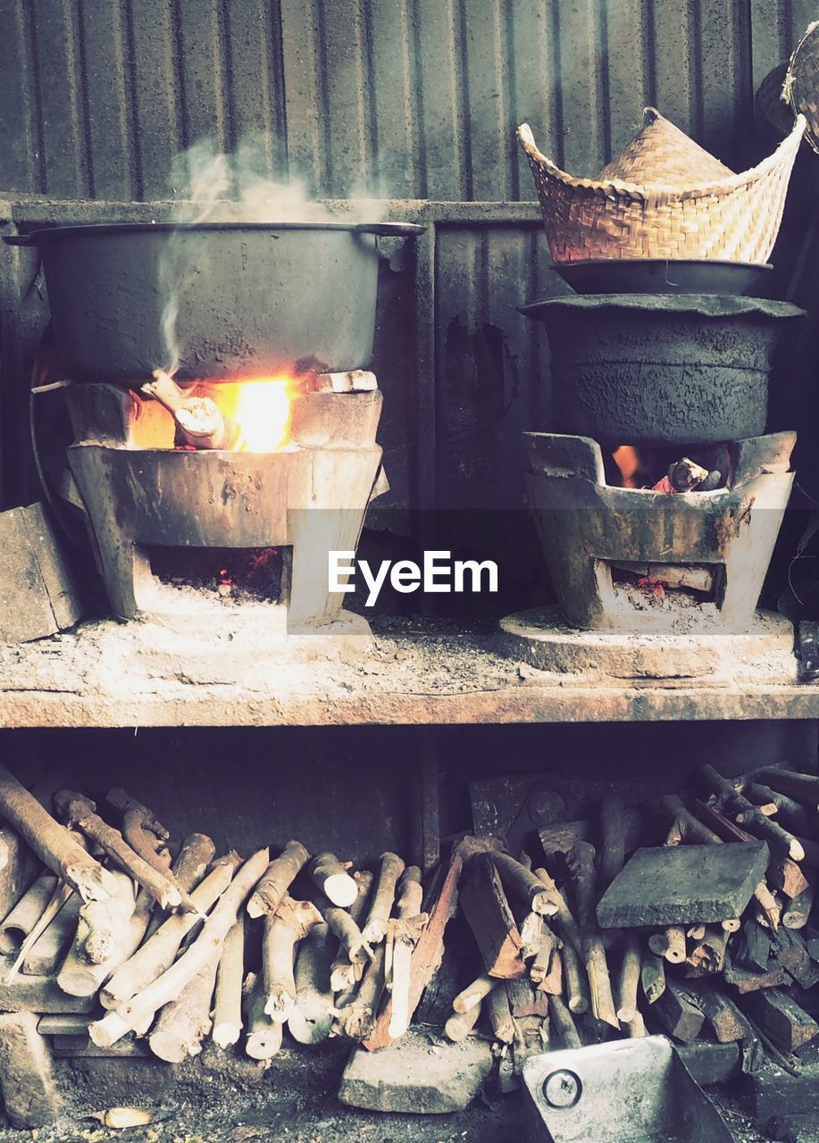 CLOSE-UP OF BURNING CANDLES ON METAL IN CONTAINER