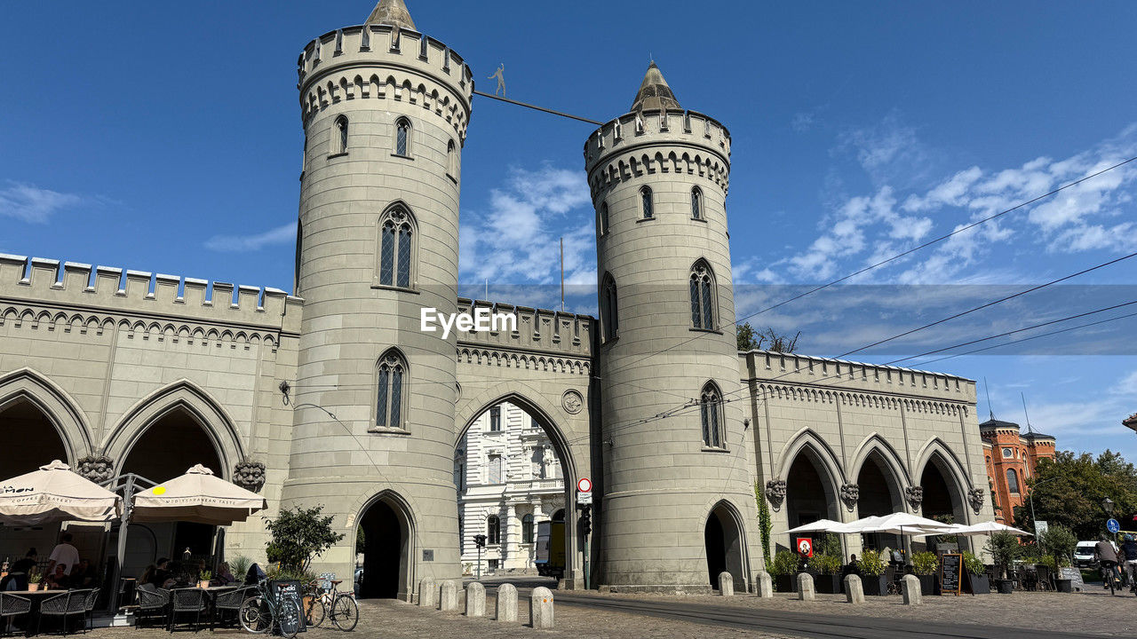 architecture, built structure, building exterior, sky, travel destinations, city, building, arch, landmark, religion, place of worship, nature, travel, history, belief, transportation, the past, day, blue, tourism, street, spirituality, outdoors, cloud, worship, tower, mode of transportation, group of people