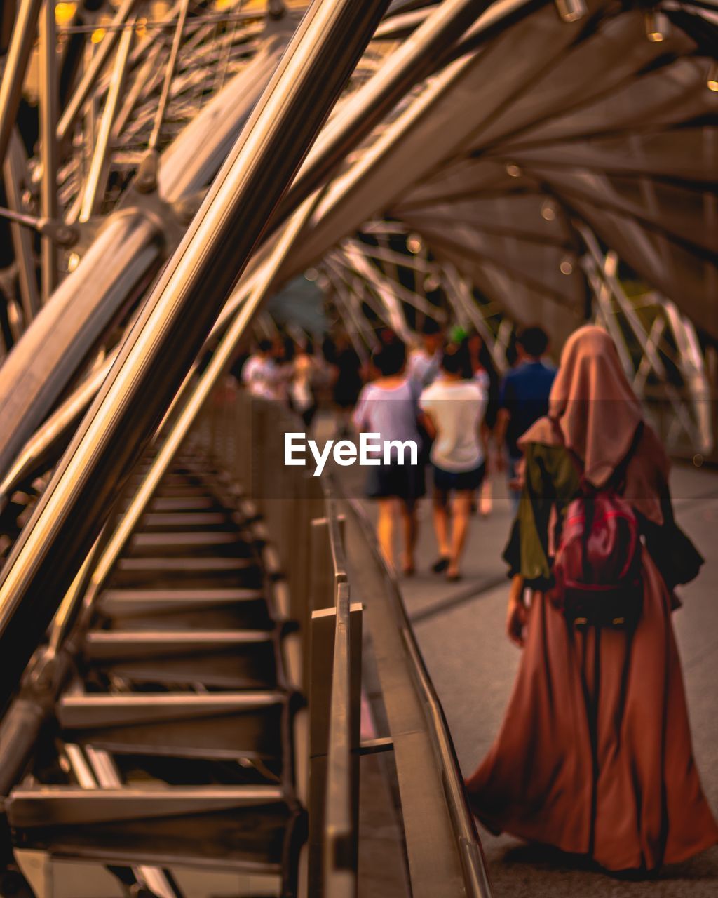 Rear view of people walking on helix bridge