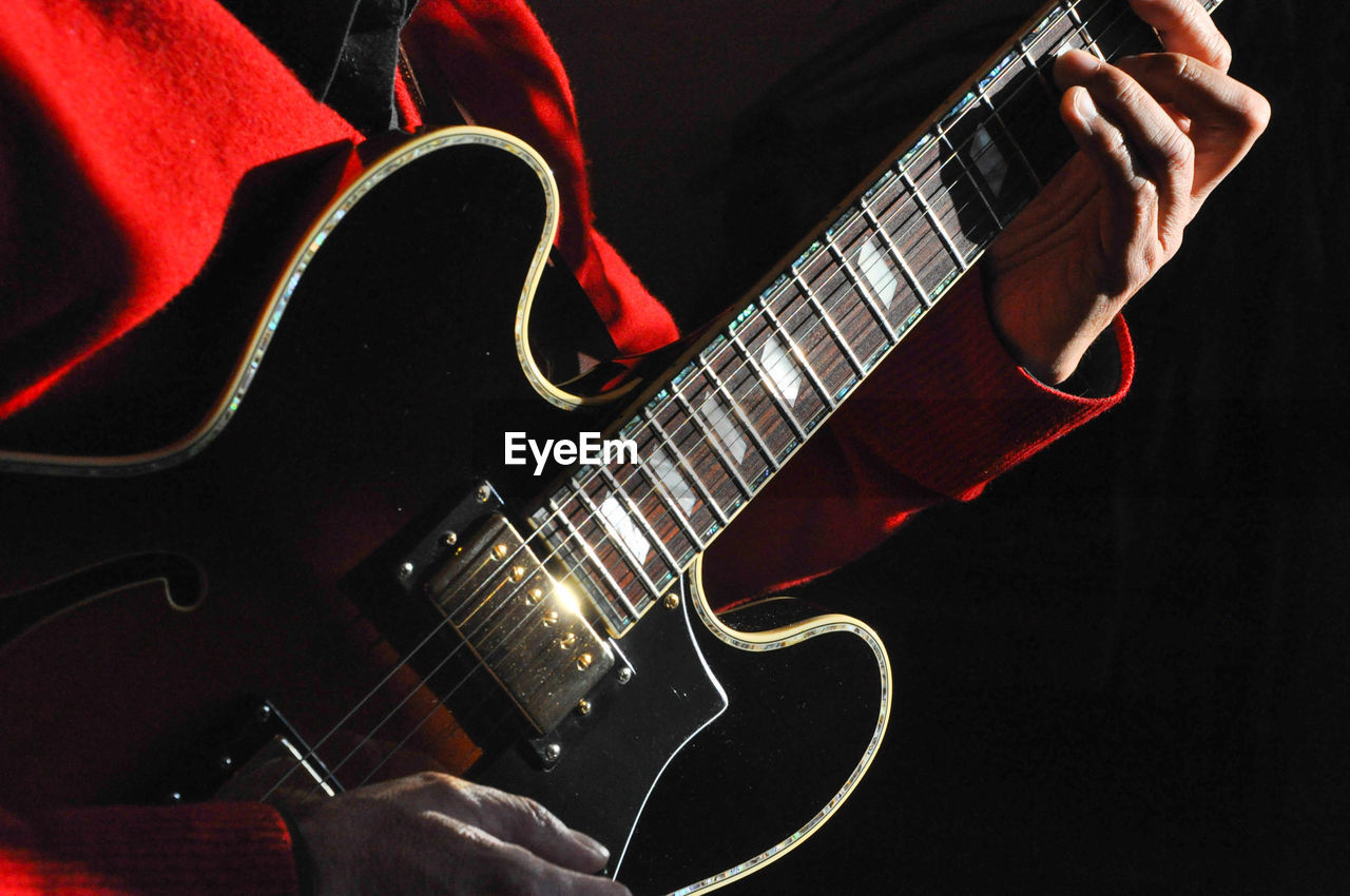 Cropped image of man playing guitar