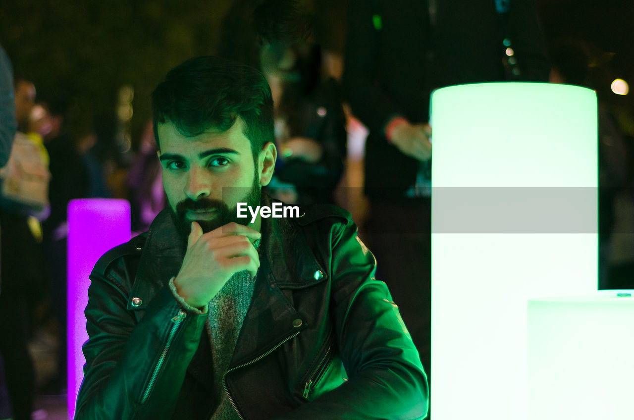 Portrait of bearded young man wearing leather jacket in nightclub