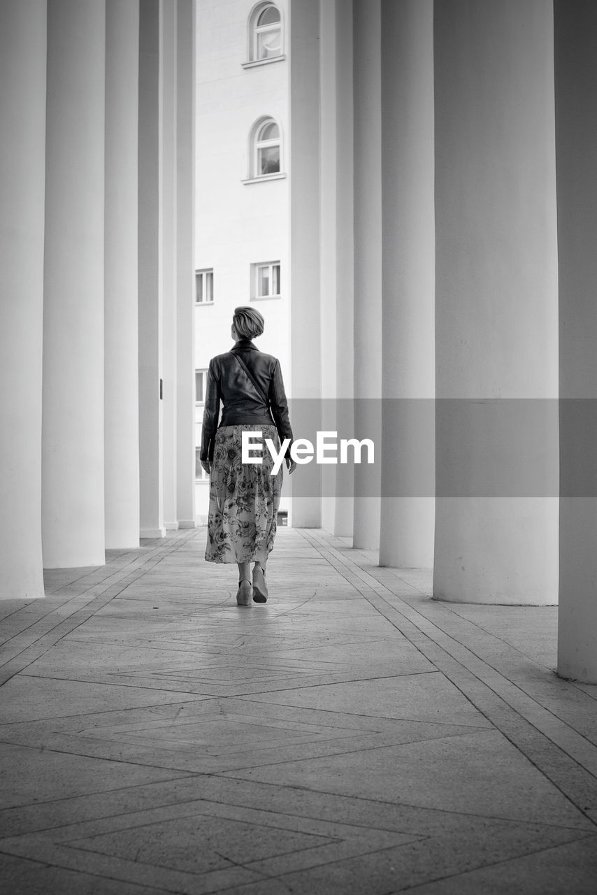 Full length rear view of woman walking in building