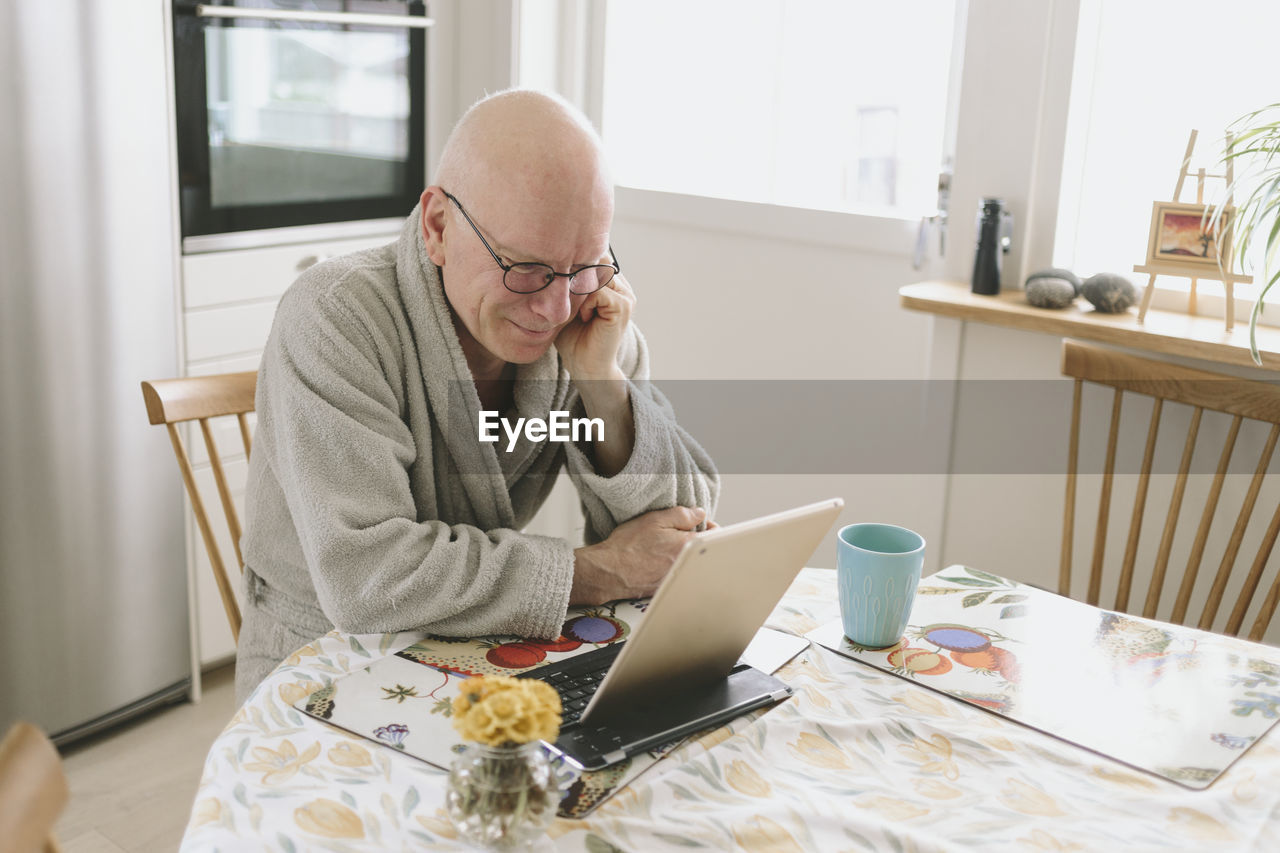 Man sitting at table and having video chat on tablet