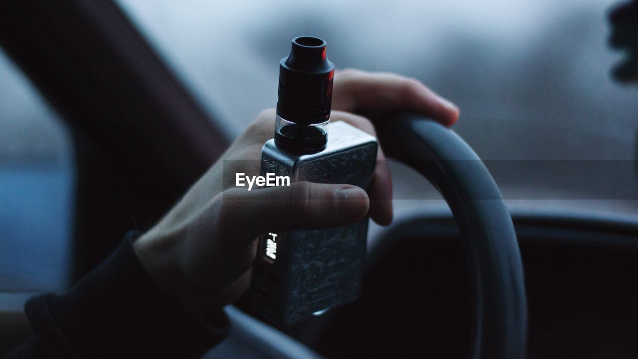 Cropped hand holding equipment while driving car