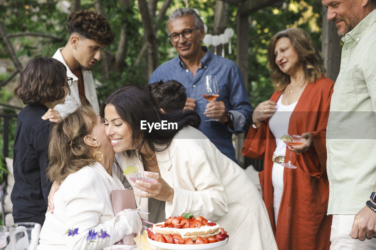 Happy women hugging each other during midsummer dinner party