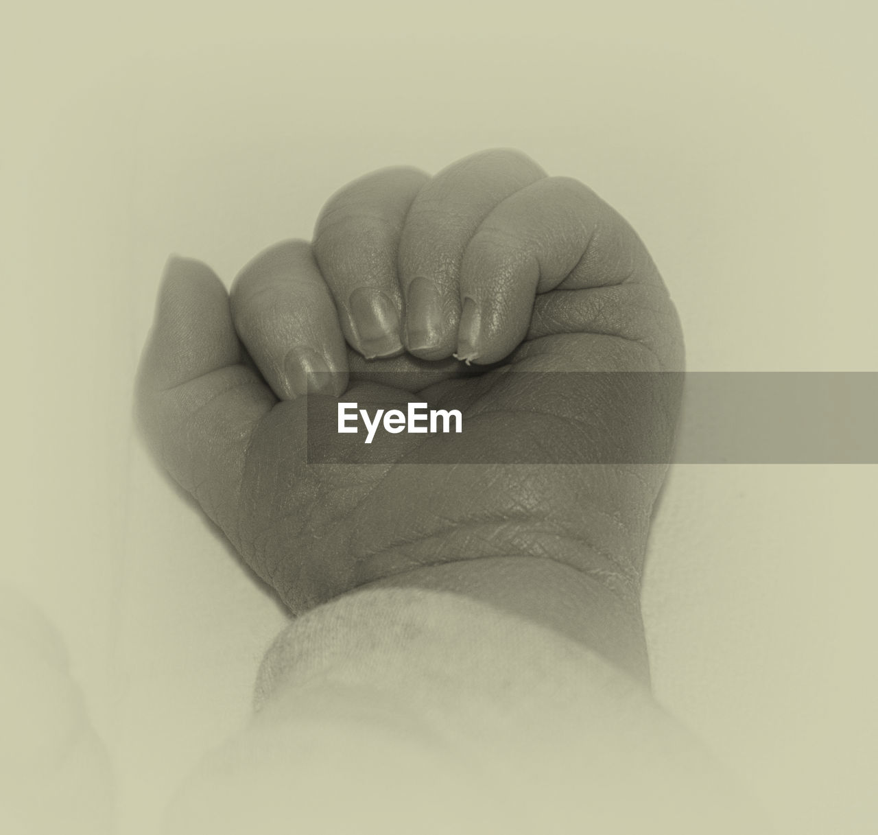 Cropped image of baby hand against white background