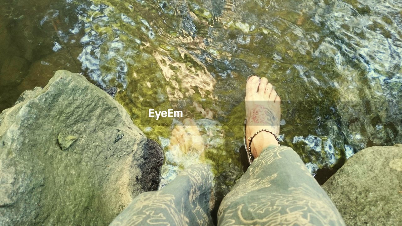 LOW SECTION OF WOMAN STANDING ON WATER