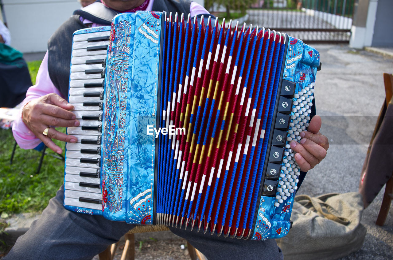Street musician playing colored accordion