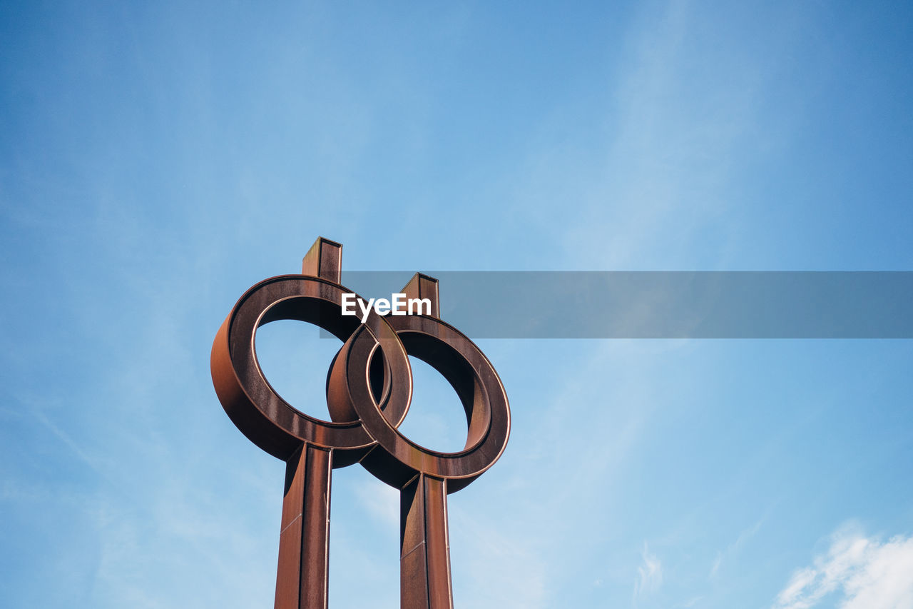 LOW ANGLE VIEW OF METALLIC STRUCTURE AGAINST BLUE SKY