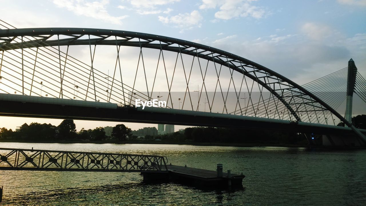 BRIDGE OVER RIVER WITH BUILDINGS IN BACKGROUND