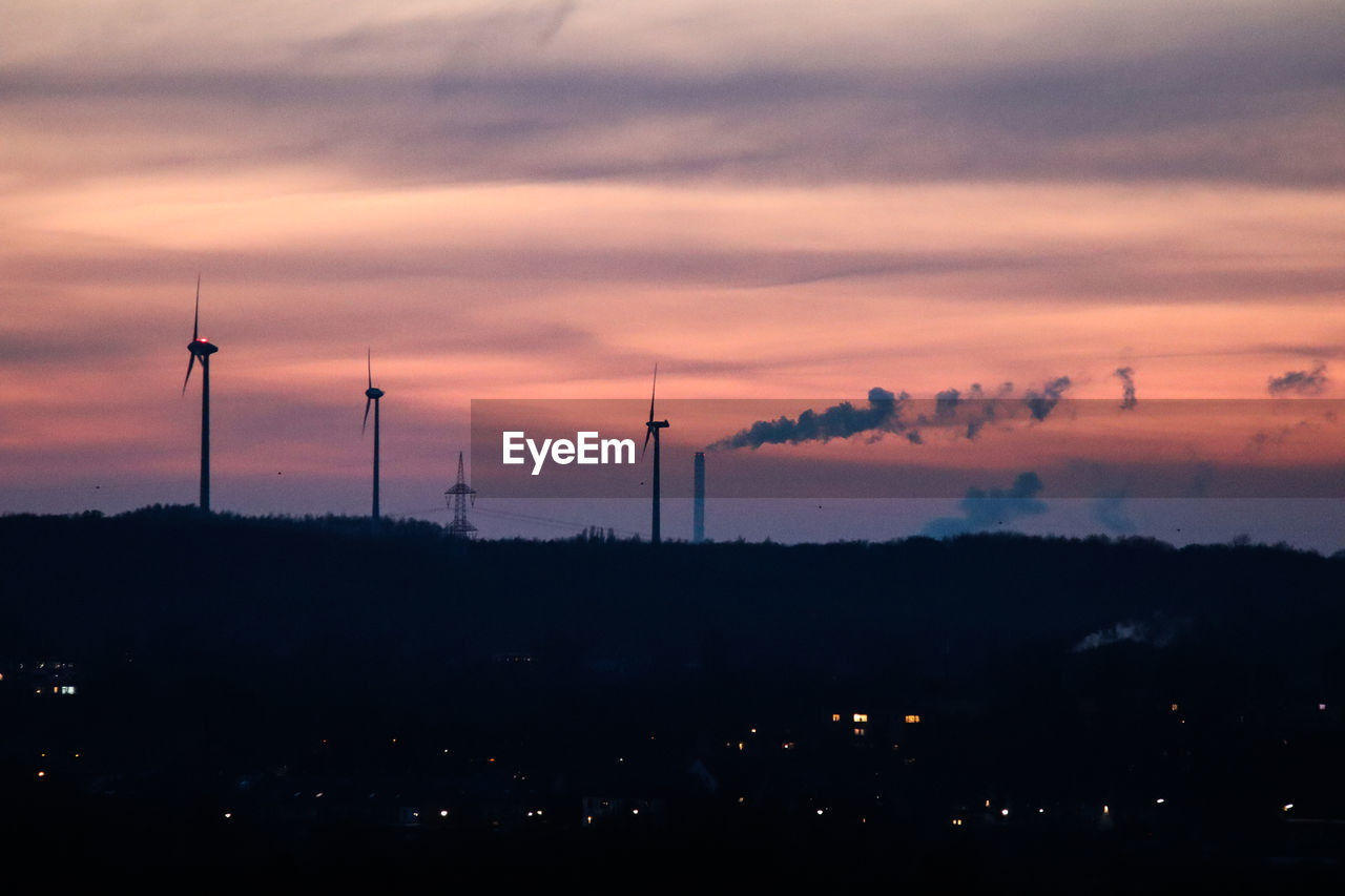 SILHOUETTE SMOKE STACK AGAINST SKY AT SUNSET