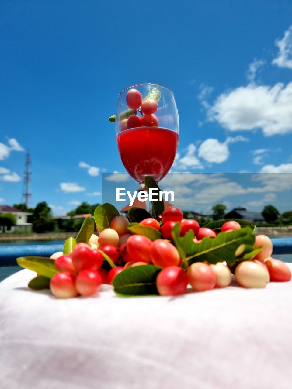 CLOSE-UP OF FRUITS ON GLASS AGAINST BLUE SKY