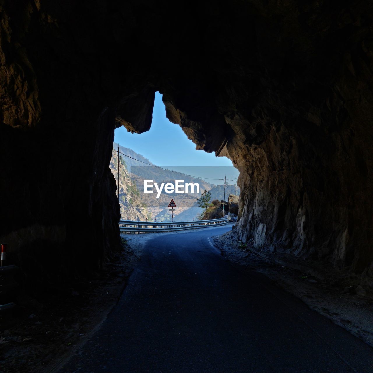 Scenic view of road passing through natural tunnel