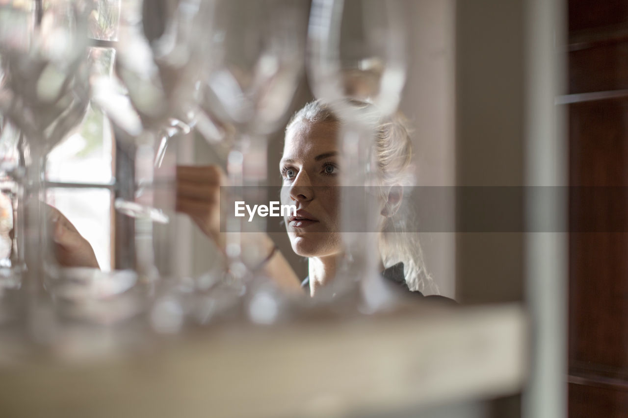 Waitress examining wine glasses