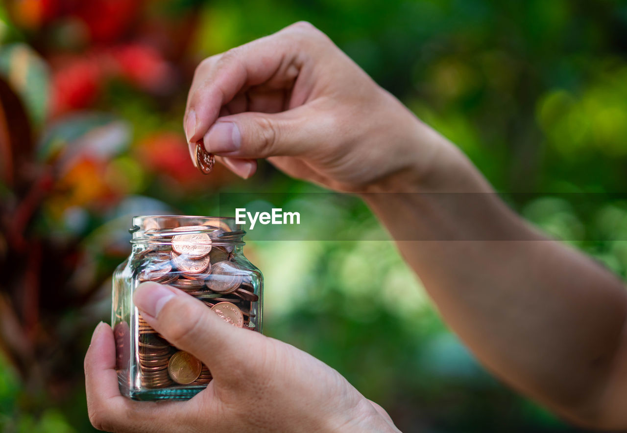 CLOSE-UP OF PERSON HAND HOLDING JAR