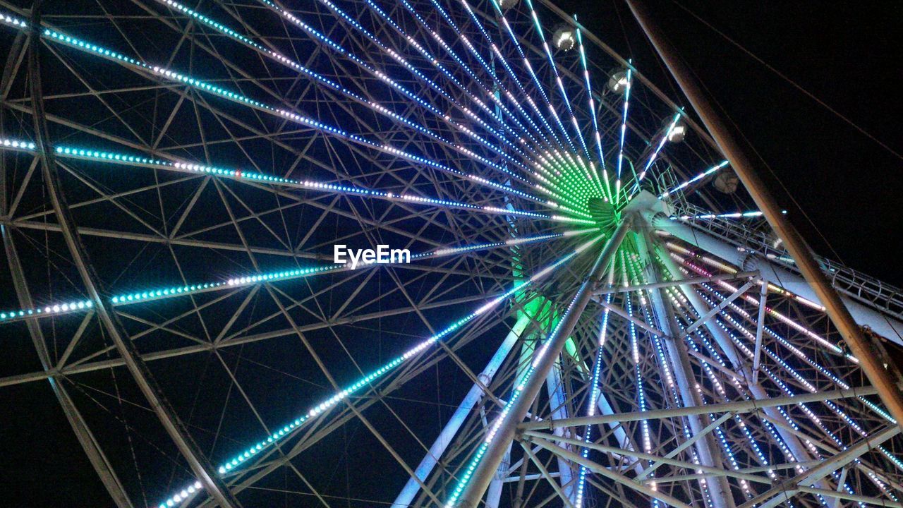 Low angle view of illuminated ferris wheel against sky at night