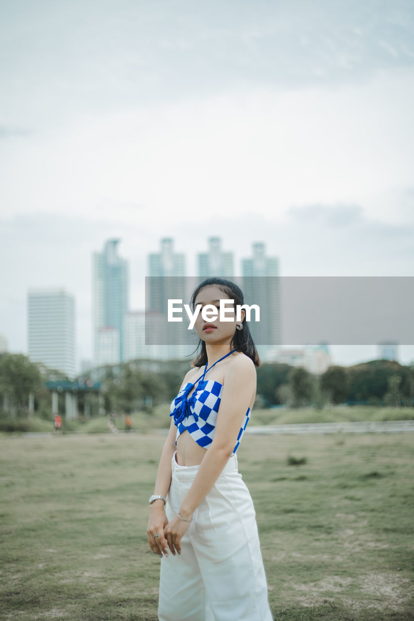 Portrait of young woman standing on field