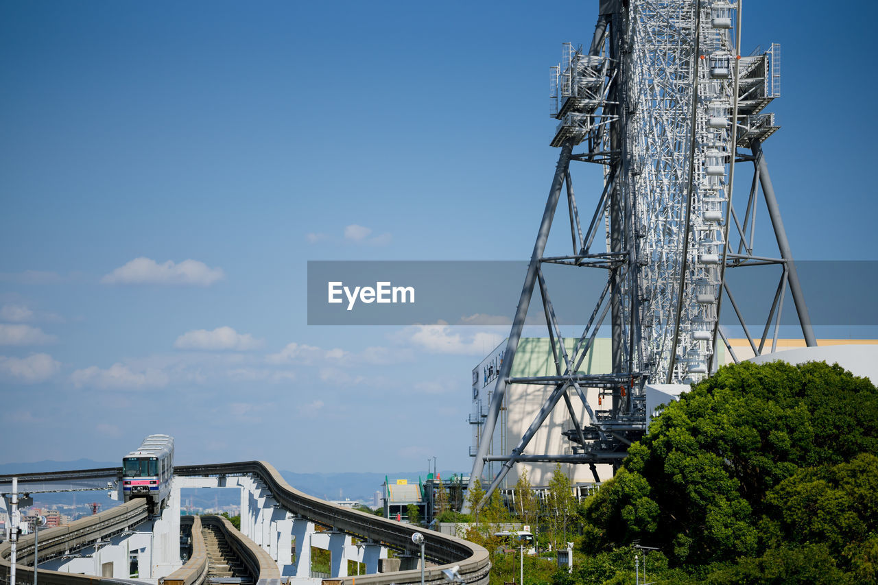 Low angle view of ferris wheel and bridge against sky