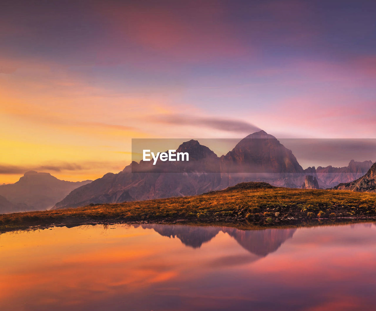 SCENIC VIEW OF LAKE AND MOUNTAINS AGAINST SKY DURING SUNSET